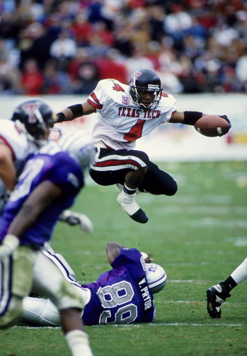Texas Tech Red Raiders running back Byron Hanspard (4) hurdles Texas Christian Horned Frogs linebacker Vincent Pryor (89) at Amon G. Carter Stadium. 